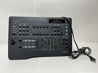 Front view of Panasonic Digital AV Mixer W-J-AVE5 showing buttons, sliders, labels, and power cord.