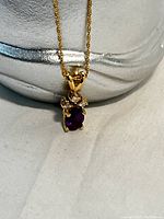 Close-up of pendant showing oval amethyst and clear accent stones
