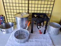 Wide view showing all items in the El Loco fryer set including burner, pot with lid, fry basket, pan, and insert basket.