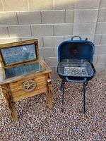 Photo showing side-by-side small black grill with cooking grate and wooden ice chest with open lid revealing insulation lining