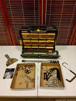 Photo showing Dewalt small compartment organizer, assorted fasteners in cardboard boxes, a putty knife, and Husky torque wrench.