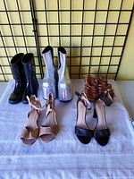 All six pairs of women's shoes displayed on a white cloth on a table against a black grid background.