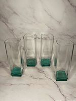 Four Luigi Bormioli Van Gogh cordial glasses displayed together showing clear crystal with green bases.