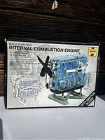Box front showing Haynes internal combustion engine model kit packaging with image of transparent model engine and propeller, emphasizing ignition sound feature.