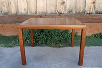 Side view of rectangular wooden table with straight legs showing overall form and finish