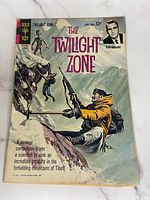The Twilight Zone comic book cover showing a man climbing a mountain with a rifle, Gold Key publisher, priced at 12 cents