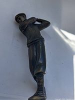 Full side view of the bronze golfer statue showing clothing details and lack of base and club