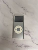 Front view of silver Apple iPod Nano 2nd Gen showing screen and click wheel.