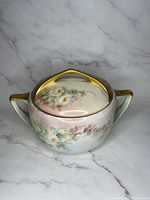 Front angled view of the Rosenthal Donatello rose sugar bowl, showing floral painted design and gold trim handles and lid.