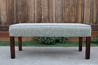 Front view full bench showing wood legs and upholstered seat.