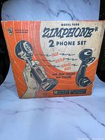 Front of original box showing Zimphone Model 4600 2 Phone Set branding and highlighting features like talk, listen, signal buzz, and high fidelity volume.