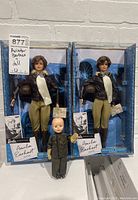 Full lot showing two boxed Barbie Amelia Earhart dolls and one vintage doll in front.