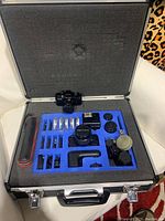 Foam-lined aluminum case opened showing Pentax Auto 110 cameras, lenses, flash and accessories