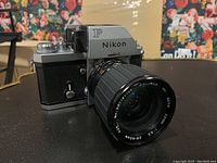 Three-quarter front view of Nikon F camera body with attached zoom lens and prism viewfinder