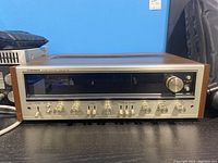 Front view showing aluminum panel, control knobs and tuning display