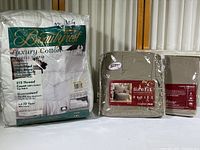 Photo showing Beautyrest mattress topper packaging on left and two Sure Fit T-Cushion furniture covers on right in their original packaging.