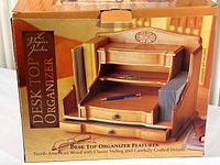 Photo of the retail box showing the desk top organizer with two drawers and lidded top section, classic wood design.
