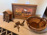 Overview of disassembled cuckoo clock parts, artwork and basket