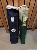 Photo showing navy blue and green carry bags containing camping cot and camping chair.