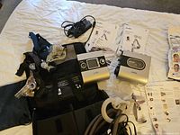Overhead shot of CPAP machine, mask, hoses, manuals, carrying bag, power supply, and boxed accessories