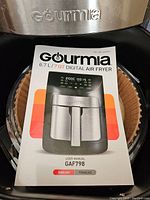 Close up of Gourmia air fryer brand logo on front panel and user manual showing model GAF798 and product image.