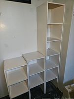 Four white stacking cubes arranged in varying heights showing open shelves and configuration possibilities.