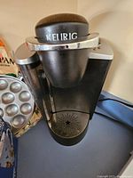 Black Keurig single-serve coffee maker on counter, front view