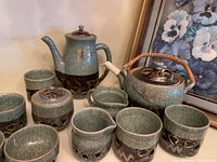 Photo showing the entire pottery tea set including teapot, coffee pot, sugar bowl, creamers, and cups.