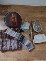 Lot overview showing all items including the round tin box with a lady painting, fur muff, beaded handbag, striped belt, white coin purse, metal hand mirror, and embossed metal compact case.