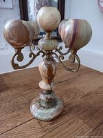 Front view of the marble candelabra showing five candle holders and detailed metal arms.