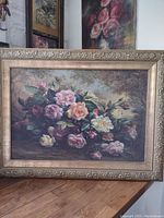 Full view of the framed artwork showing a bouquet of roses with detailed ornate gold-toned frame.