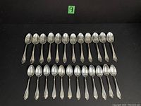 24 spoons arranged in two rows (12 tablespoons above, 12 teaspoons below)