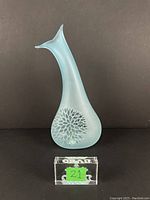 Front view of light blue frosted glass vase with clear glass floral-like decoration and tapered neck.