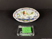 Angled photo of the oval Faenza dish displaying its shape and hand-painted flower motifs.