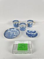 Overview of three cups and two saucers arranged on white background