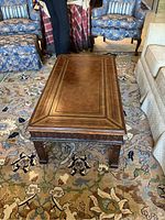 Top view of rectangular coffee table with gold pressed inlay on wooden surface, showing decorative border patterns and smooth top.