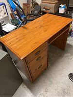 Overview of wooden desk showing top surface and side drawers.