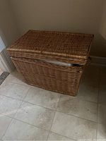 Closed wicker trunk showing the broken part on the lid's side