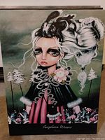 Front view of the art print depicting a stylized girl with large eyes, white hair, and an animal on her head in a whimsical landscape with text 'Angelina Wrona' at bottom.