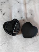 Photo showing Fitbit fitness tracker, charging cable, and heart-shaped storage box