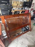 Photo of the full wooden bed headboard showing its slatted design and finish.