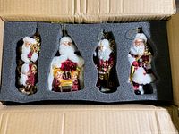 Set of four vintage glass Santa Claus Christmas ornaments in protective foam inside cardboard box.