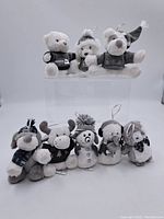 Full set of nine vintage plush Christmas ornaments laid out showing various animal and holiday characters with hanging loops.