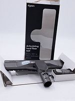 Dyson vacuum head and attachment in original box with packaging showing articulating hard floor tool feature