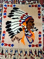 Full view of the rectangular vintage hand woven wool rug with Native American chief profile and border.