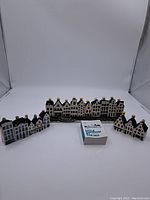 Full view of the Dutch house ceramic ornaments in three groups with small booklet in front, showing overall set condition and scale.