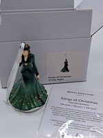 Figurine posed in front of its box and product information, showing the full figure and box label.