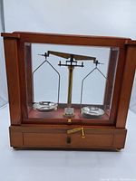 Front view of the wooden and glass enclosed balance