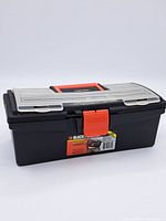Closed Black & Decker 14 inch plastic tool box with red latch and handle.