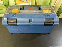 Closed blue plastic toolbox with two black latches and a handle on top, showing exterior condition.